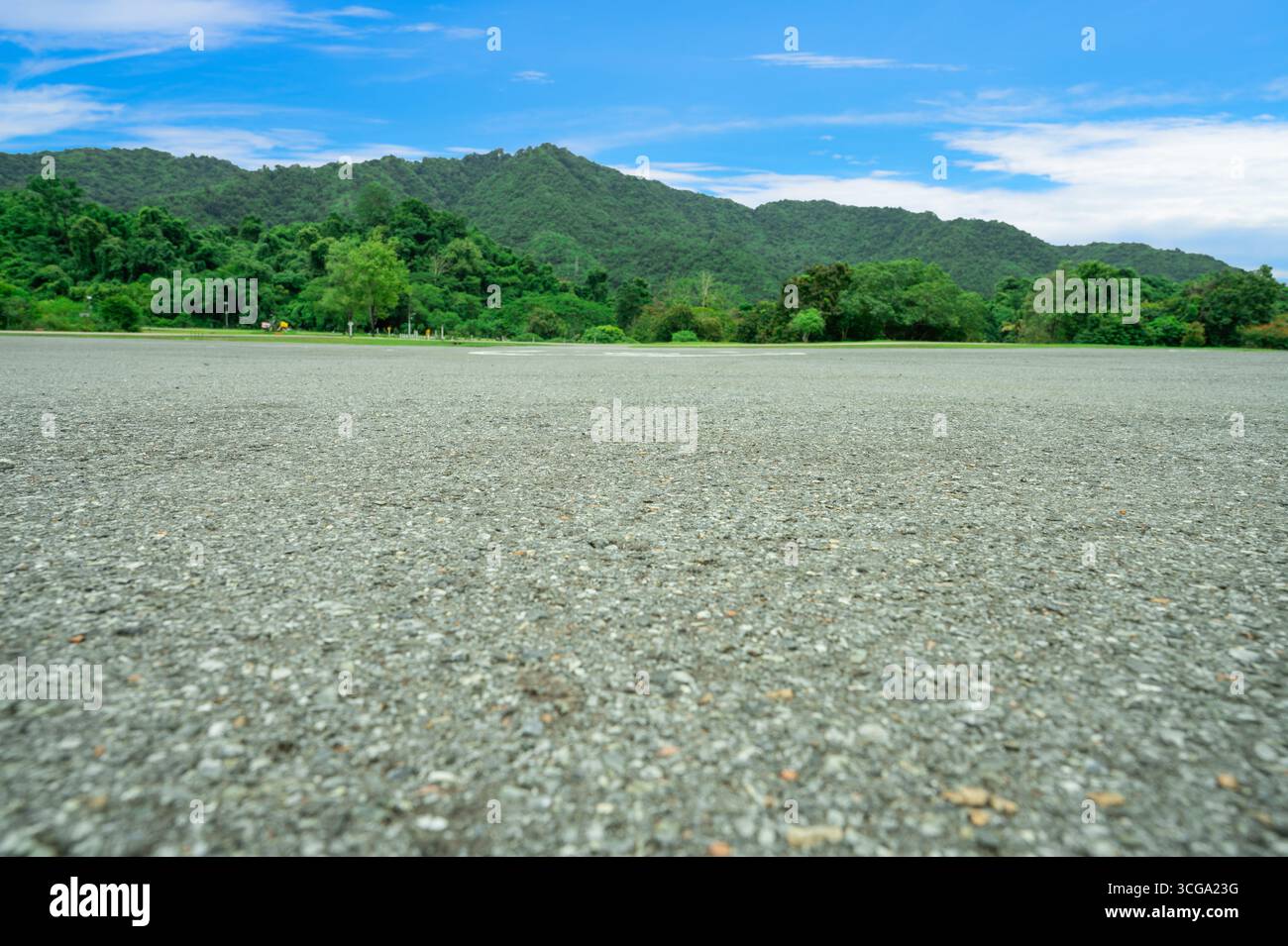 Piste d'atterrissage d'hélicoptère vide avec de l'asphalte avec fond vert de forêt de montagne fournissant un accès de transport médical d'urgence à la zone sauvage éloignée Banque D'Images
