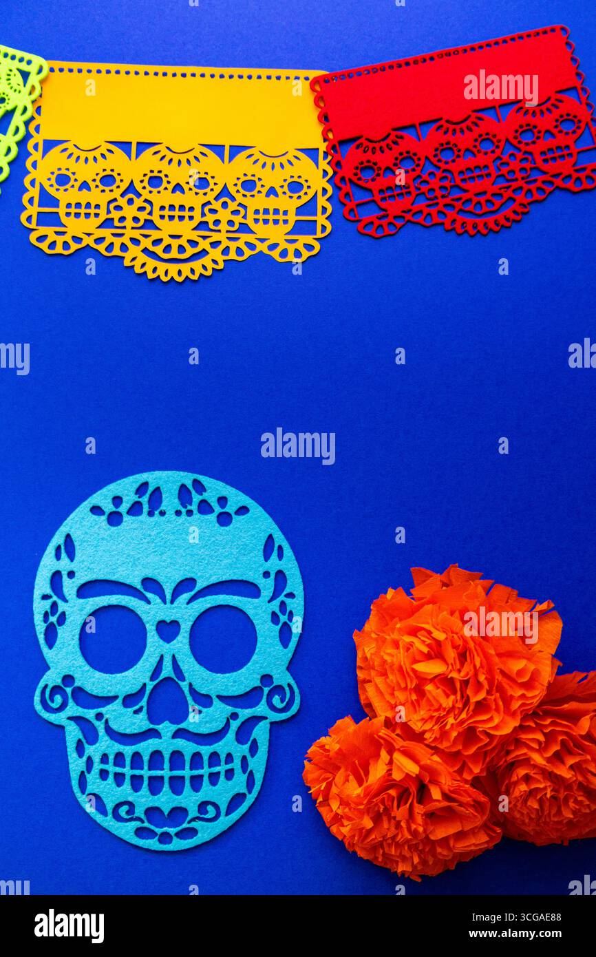 Le traditionnel décor mexicain de la fête des morts présente des bannières picado en papel éclatantes, une découpe en papier crâne de sucre bleu et des fleurs de souci orange vif Banque D'Images