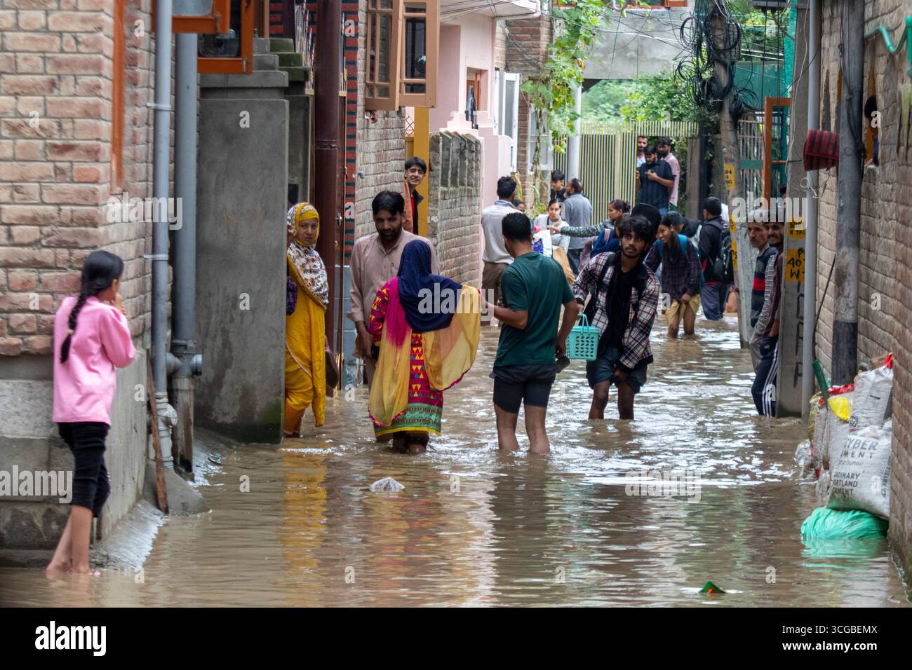 Srinagar, Inde. 27 août 2025. Les gens pataugeaient dans une rue inondée de la capitale Srinagar. Mercredi, des pluies torrentielles ont gonflé la rivière Jhelum au Cachemire au-delà de la marque de danger, incitant les autorités à déclarer une inondation, alors que des glissements de terrain et des inondations violentes ont déchaîné dans la région voisine de Jammu, tuant plus de 30 personnes, emportant des maisons, des routes et des ponts, et coupant les télécommunications sur une grande partie du territoire himalayen. Crédit : SOPA images Limited/Alamy Live News Banque D'Images