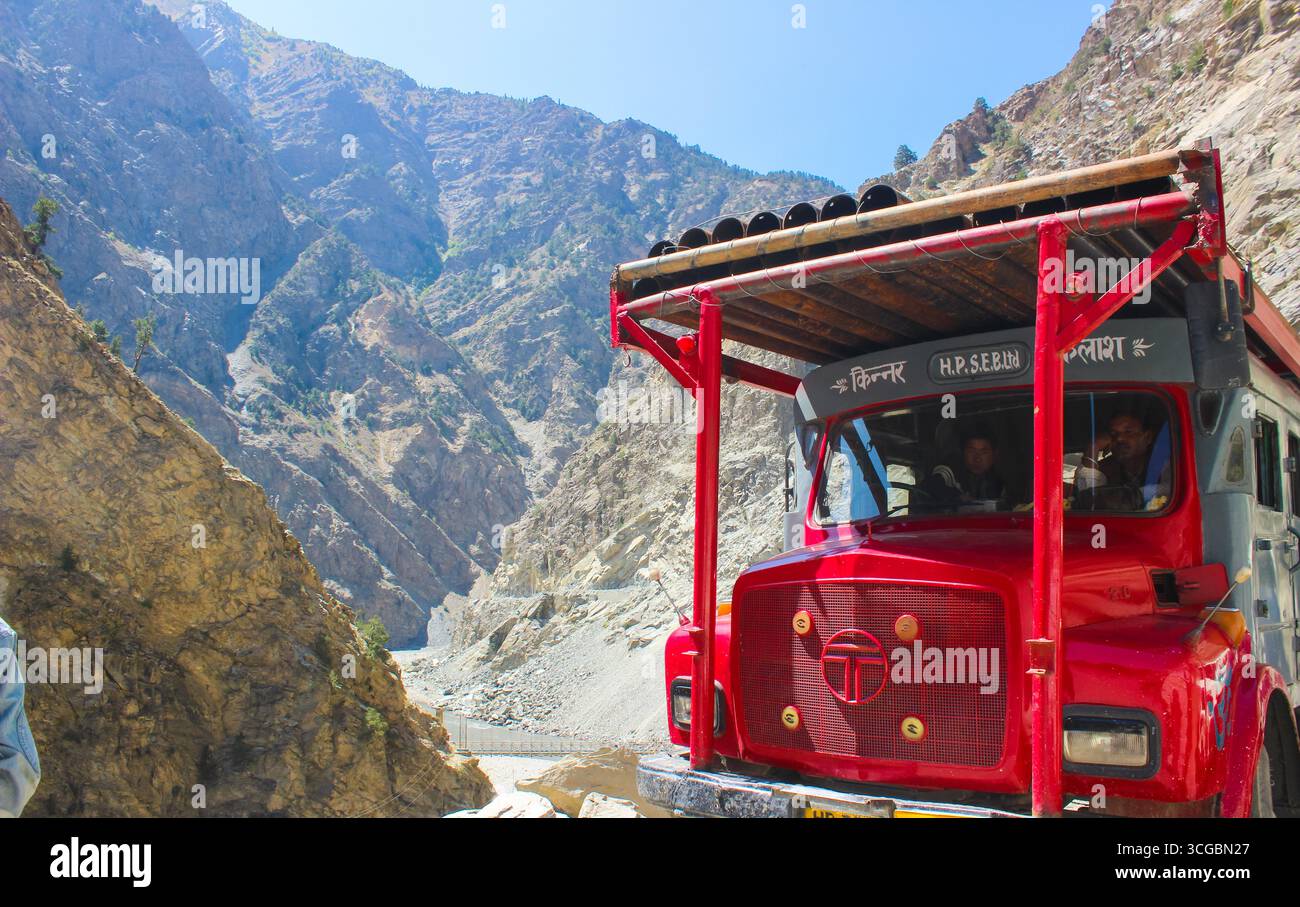 Camion coloré conduisant à travers les paysages accidentés de la vallée de Spiti, Himachal Pradesh, entouré de hautes montagnes, terrain aride, et pittoresque Himal Banque D'Images