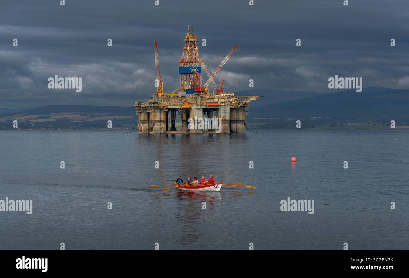 Cromarty Ross et Cromarty Scotland bateau à rames passant la plate-forme pétrolière déclassée ou plate-forme Noble Endeavor dans le Firth Banque D'Images