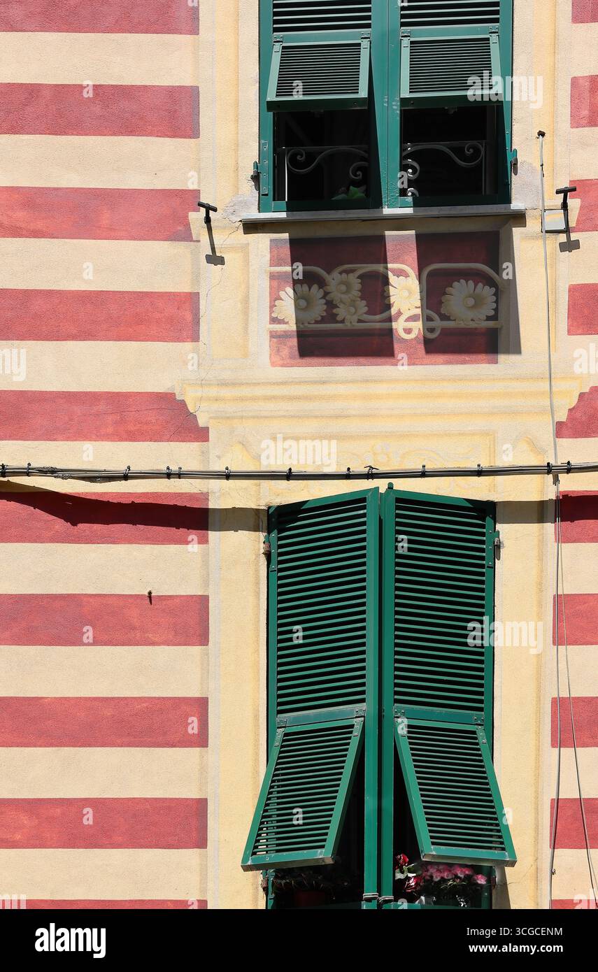 252 bandes rouges et crème et cadres de fenêtres sculptés, trompe-l'oeil sur la façade d'une maison sur la place Piazza Giovanni Minzoni. Monterosso al Mare-Ligurie Banque D'Images