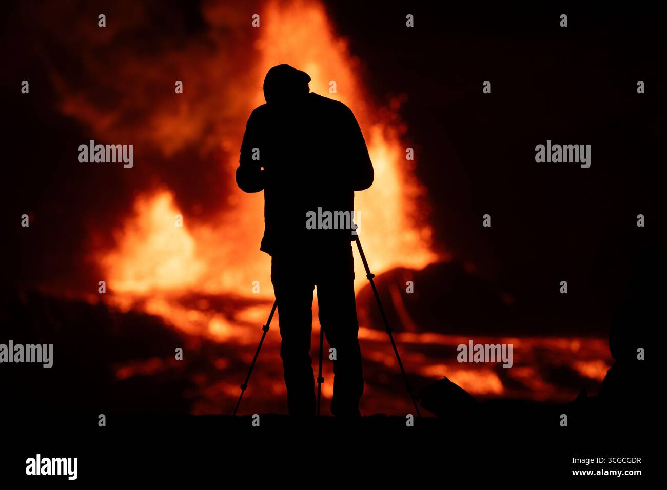 Un photographe réalise un cliché de deux fontaines de lave chaude tirant depuis le cratère Halemaumau et déversant de la lave dans la caldeira, volcan Kilauea, aux États-Unis Banque D'Images