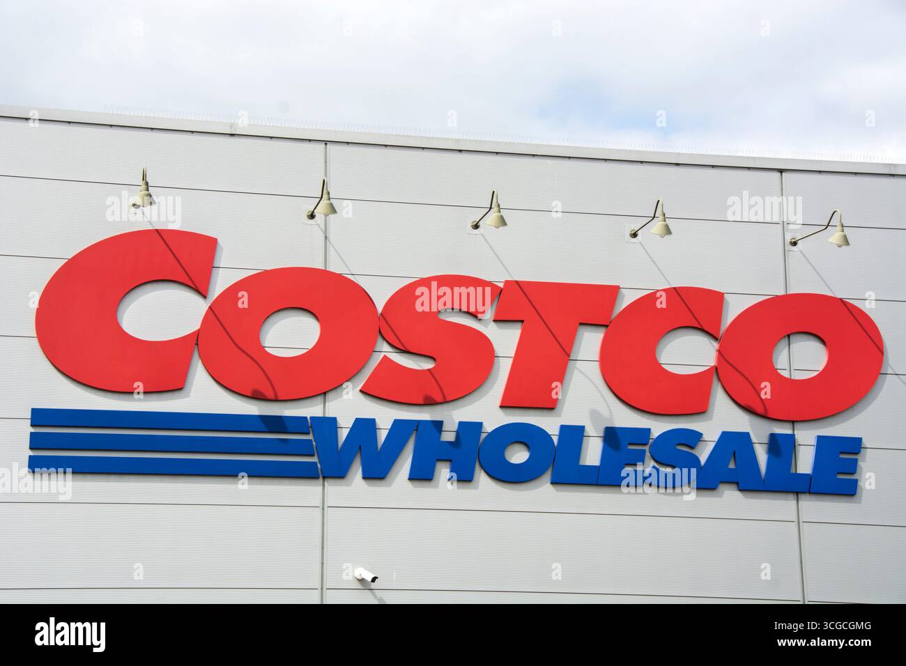Un seul membre des magasins de détail de club d'entrepôt de grande boîte, magasin de gros Costco dans la vue de face et ciel nuageux bleu Banque D'Images