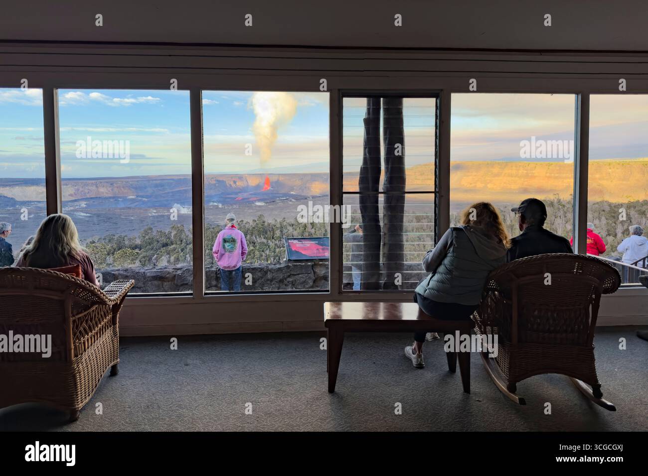 Une fontaine de lave chaude jaillit de plusieurs centaines de mètres dans le cratère Halemaumau, tandis que les visiteurs regardent l'éruption depuis Volcano House, Kilauea Volcano, Hawaii Banque D'Images