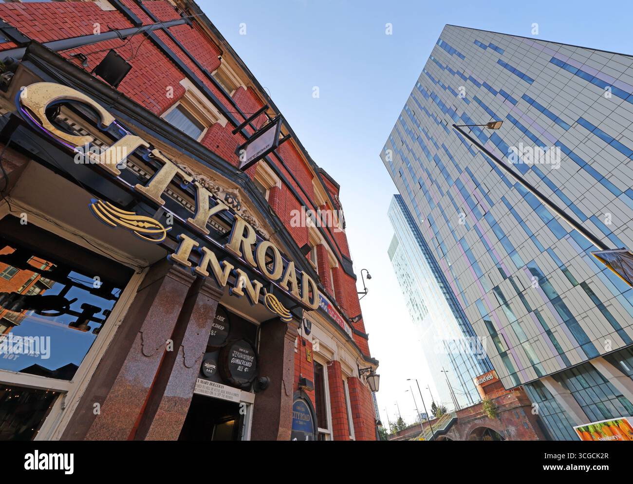Extérieur du City Road Inn dans le centre-ville de Manchester, avec la tour de verre moderne du Hilton Manchester Deansgate s'élevant en arrière-plan Banque D'Images