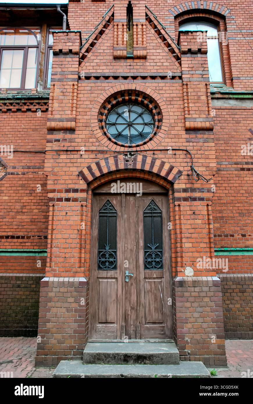 Rauschen, Russie - 02 mai 2013 - façade historique de bâtiment en briques rouges avec portes en bois et fenêtre circulaire. Banque D'Images