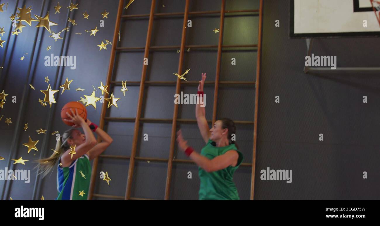 Tir joueur de basket-ball en uniforme bleu libérant la balle dans la salle de gym, le cerceau, les barres murales et les graphiques d'étoile Banque D'Images