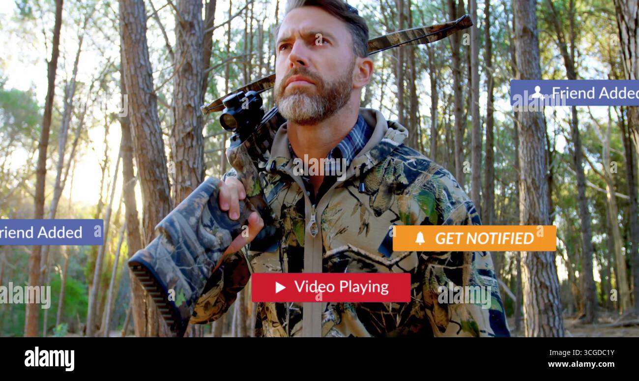 Chasseur debout regardant les pinèdes vêtu d'une veste camouflage tenant un fusil à visée, avec des renforts d'alerte Banque D'Images