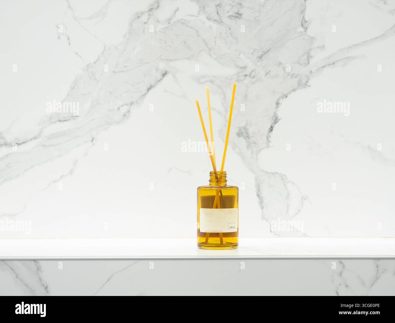 Les bâtons en bois immergés dans une bouteille en verre avec du liquide aromatique libèrent un parfum agréable, ajoutant une touche d'élégance et de fraîcheur au b moderne Banque D'Images