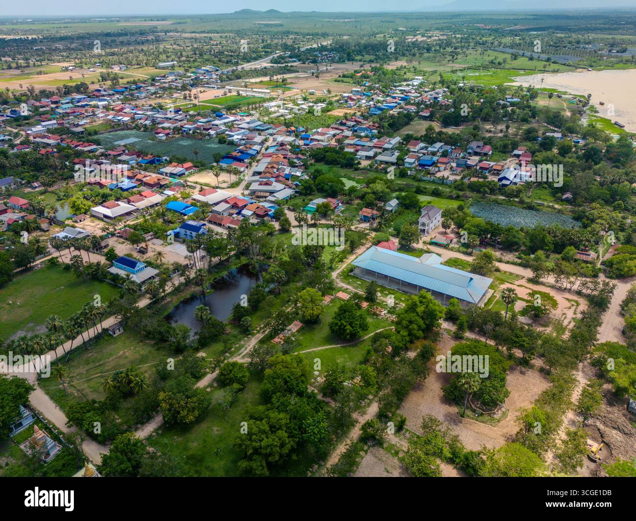Vue drone d'un village rural avec des toits colorés, des étangs et des terres agricoles près du lac Tonlé Bati dans la province de Takeo, au Cambodge. La scène met en évidence local Banque D'Images