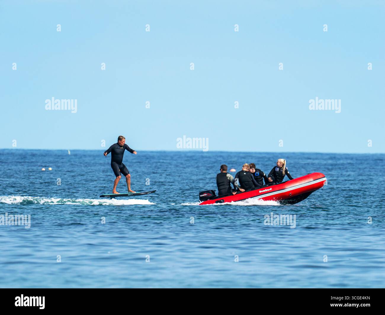 Un homme sur une planche de surf e foil au large de la plage de Beadnell dans le Northumberland, au Royaume-Uni. Banque D'Images