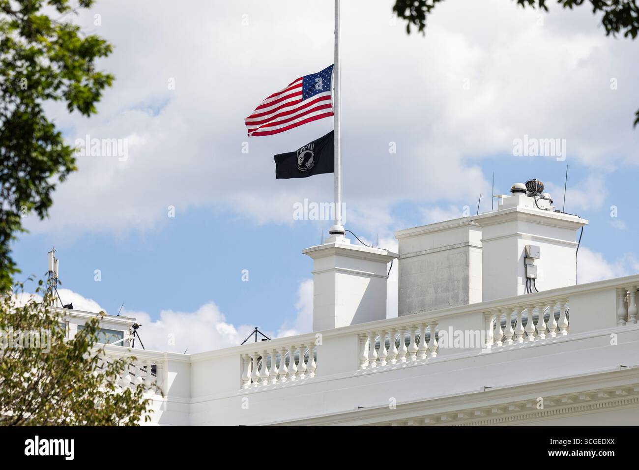Les drapeaux sont abaissés à moitié à la Maison Blanche pour les victimes d'une fusillade de masse à l'école catholique Annonciation de Minneapolis à Washington, DC, États-Unis, 27 août 2025. Au moins deux enfants ont été tués, et 17 autres personnes ont été blessées lorsque le tireur a ouvert le feu pendant la prière du matin avant l'école. Le tireur s'est ensuite suicidé. Crédit : Jim LoScalzo/Pool via CNP/MediaPunch Banque D'Images