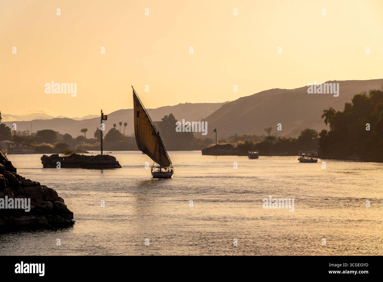 Felucca (bateau à voile égyptien traditionnel) sur le Nil au coucher du soleil à Assouan, Egypte Banque D'Images