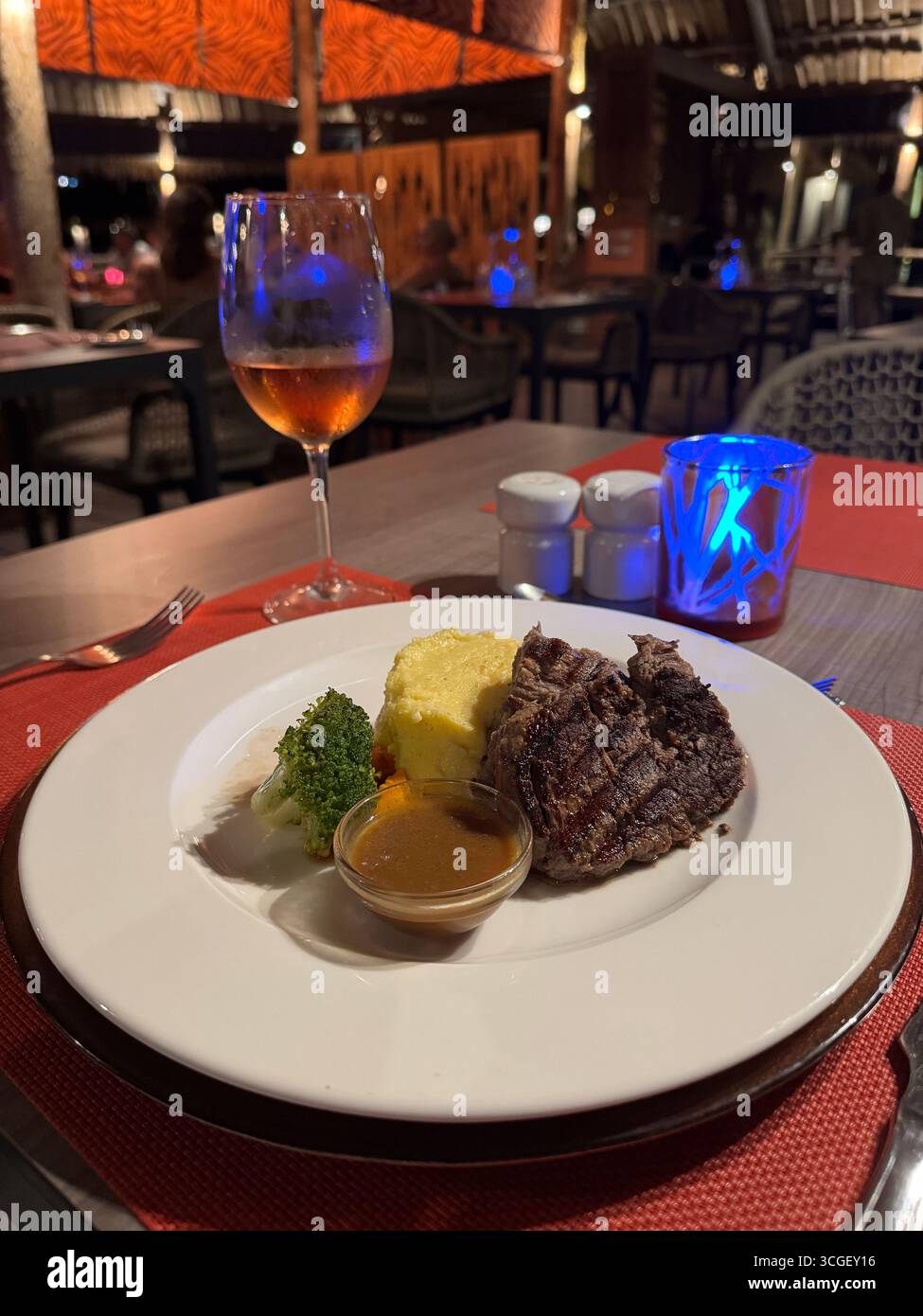 Steak grillé avec légumes, purée de pommes de terre et vin servi dans un restaurant tropical à Zanzibar, Tanzanie, représentant la gastronomie et les vacances Banque D'Images