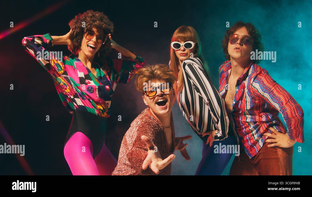 Groupe rétro Glam exprimant son charisme avec des tenues disco colorées Banque D'Images