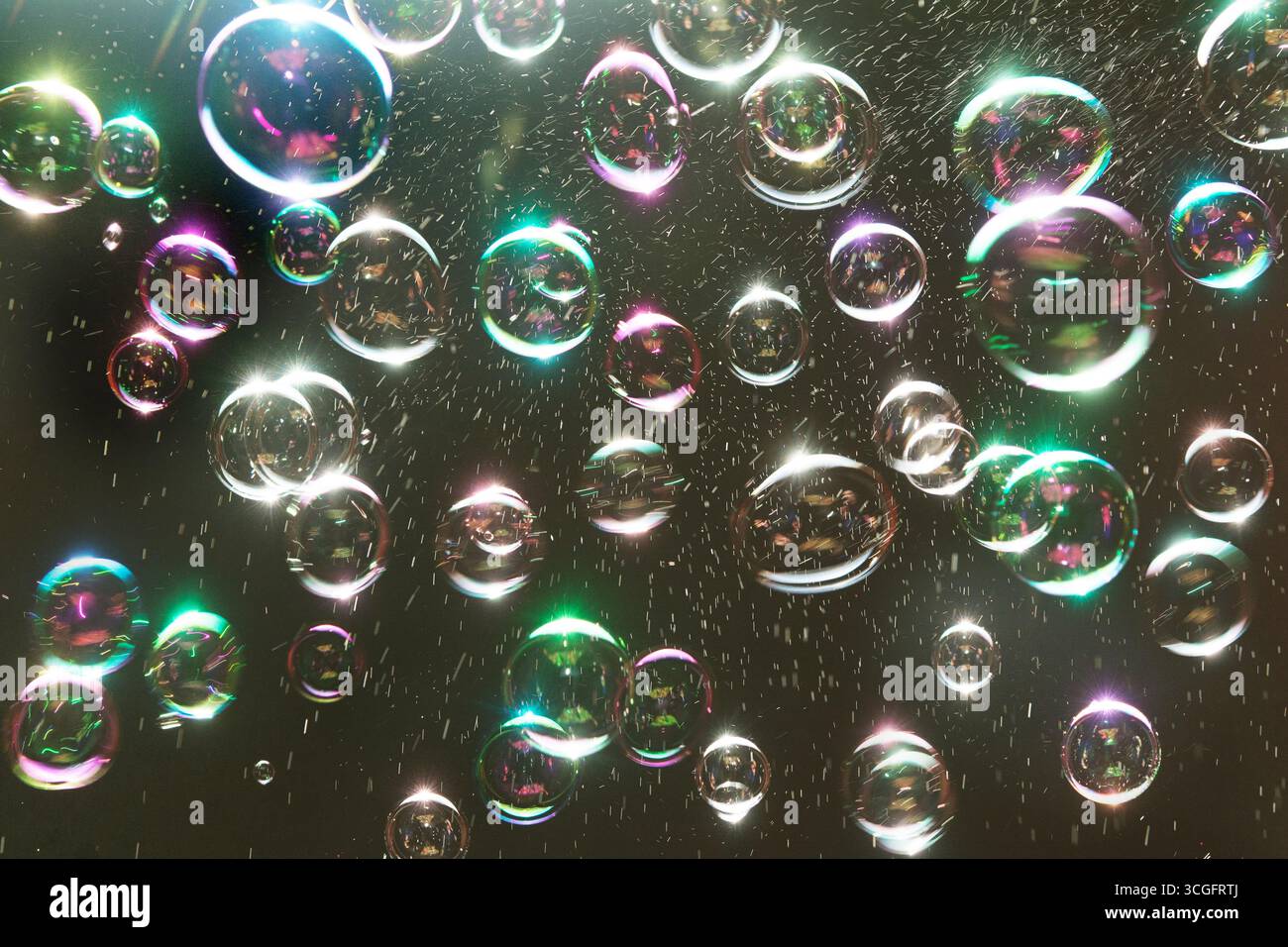 Bulles flottant sur un fond noir, avec des couleurs arc-en-ciel Banque D'Images