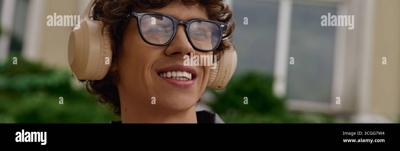 Un étudiant joyeux se promène dans un espace extérieur animé, embrassant l'air frais et la musique. Banque D'Images
