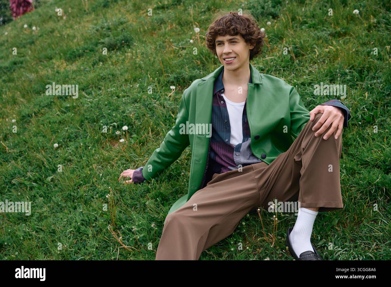 Un beau jeune étudiant se détend à l'extérieur, trempant dans la beauté sereine de la nature pendant sa promenade. Banque D'Images