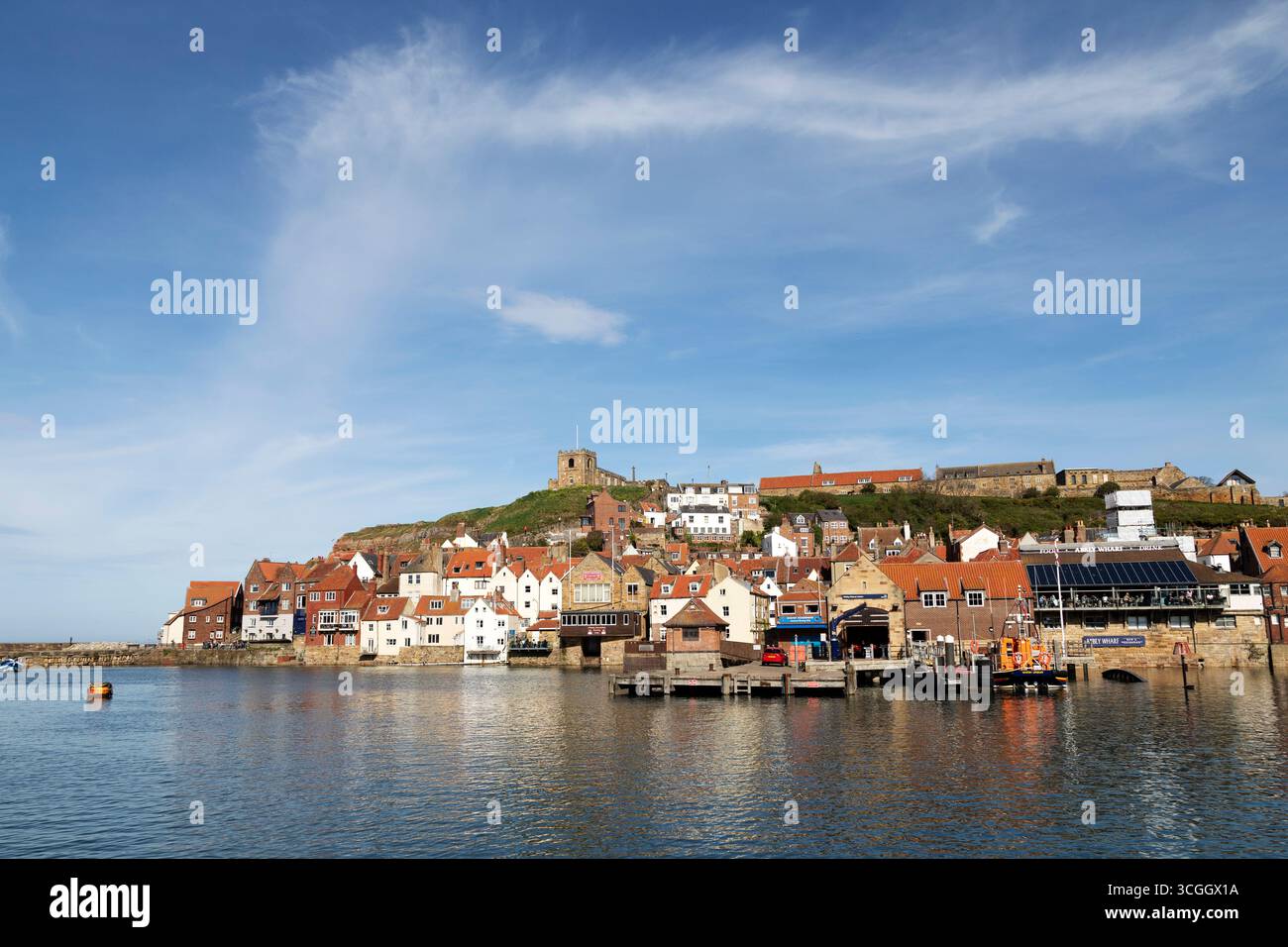 Bâtiments près de la rivière Esk à Whitby, Yorkshire du Nord, Angleterre. L'église Sainte-Marie surplombe la ville. Banque D'Images