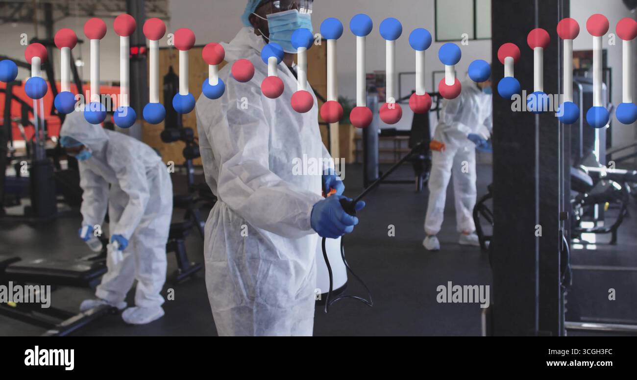 Pulvériser le travailleur de l'assainissement dans les combinaisons de nettoyage des machines au centre de fitness, en utilisant le pulvérisateur de sac à dos Banque D'Images