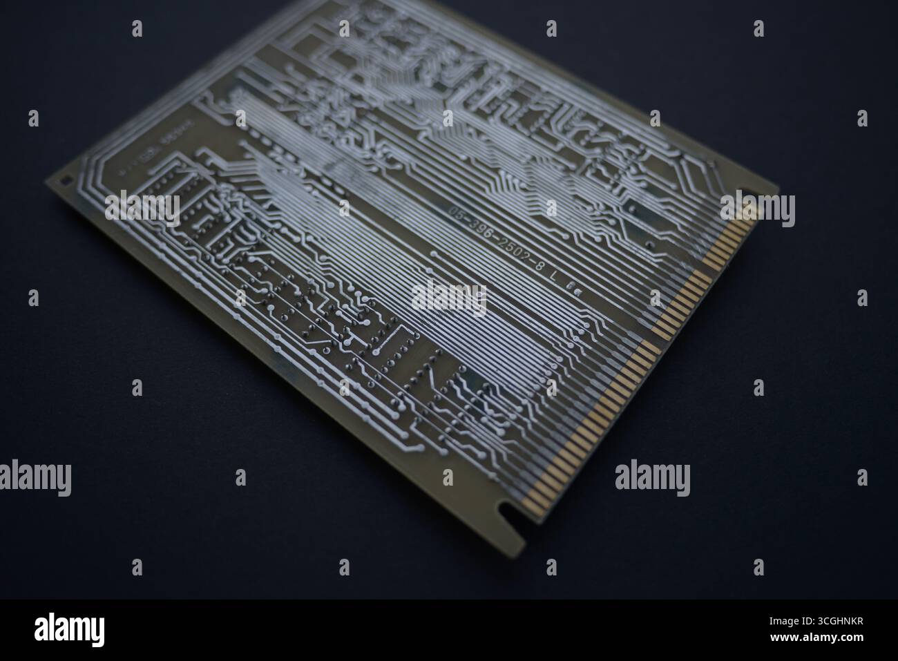 Gros plan d'une carte de circuit imprimé avec des pistes conductrices et des connecteurs visibles, illustrant la disposition des composants électroniques et la conception technologique. Banque D'Images