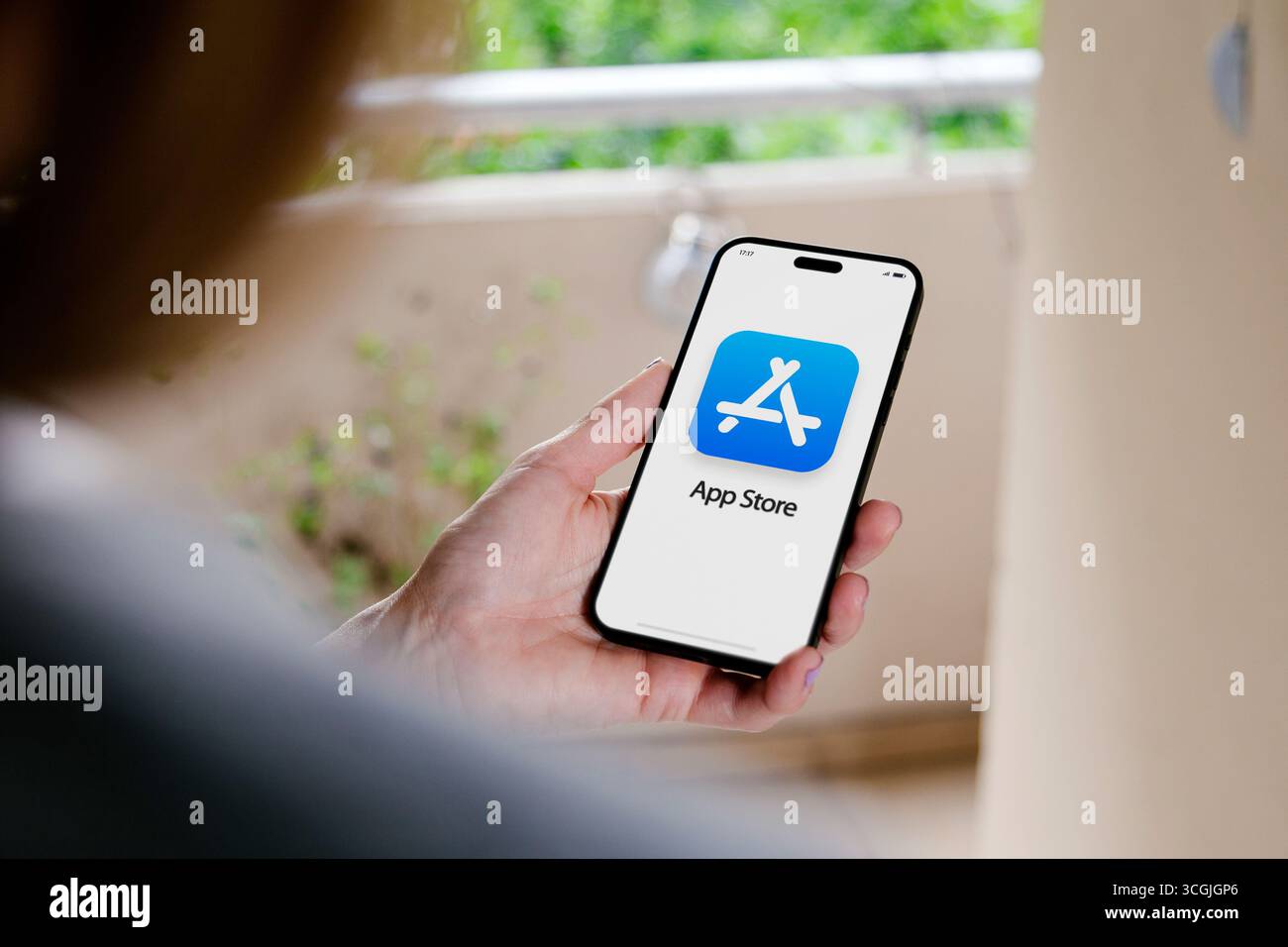 Icône AppStore sur l'écran de l'iPhone. Femme tenant un téléphone portable dans sa main avec le logotype App Store à l'écran. Icône AppStore sur l'écran de l'iPhone. La femme tient Banque D'Images