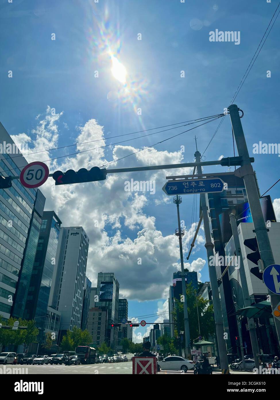 Paysage urbain diurne d'été de Séoul, Corée du Sud, à l'intersection Eonju-ro, avec de hauts bâtiments sous un ciel lumineux et des nuages cumulus spectaculaires. - Image de stock capturée avec un smartphone