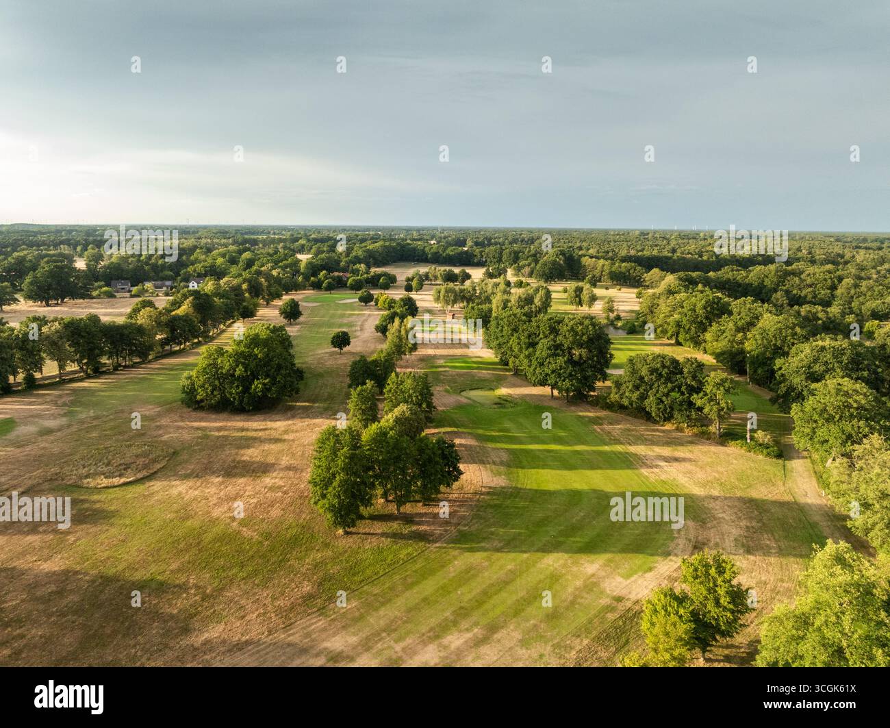 Photographie aérienne d'un terrain de golf montrant de forts contrastes entre les fairways entretenus en vert et les prairies sèches et brunes environnantes en raison du manque de pluie Banque D'Images