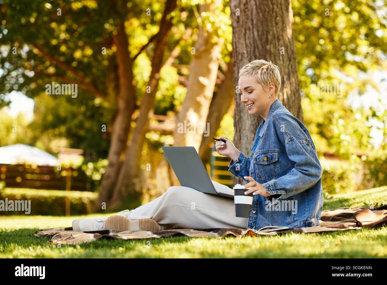 Une belle jeune femme aux cheveux courts se promène dans un parc verdoyant luxuriant, savourant la nature. Banque D'Images