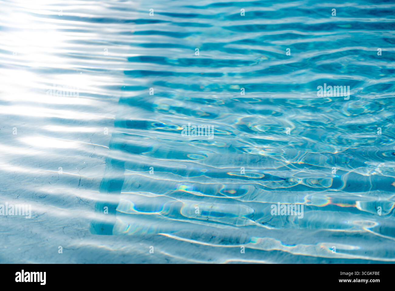Surface d'eau bleu clair brillant avec des reflets d'ondes chatoyants, texture liquide abstraite. Les ondulations et les réfractions ensoleillées créent une fraîche, relaxante, un Banque D'Images Surface d'eau bleu clair brillant avec des reflets d'ondes chatoyants, texture liquide abstraite. Les ondulations et les réfractions ensoleillées créent une fraîche, relaxante, un Banque D'Images