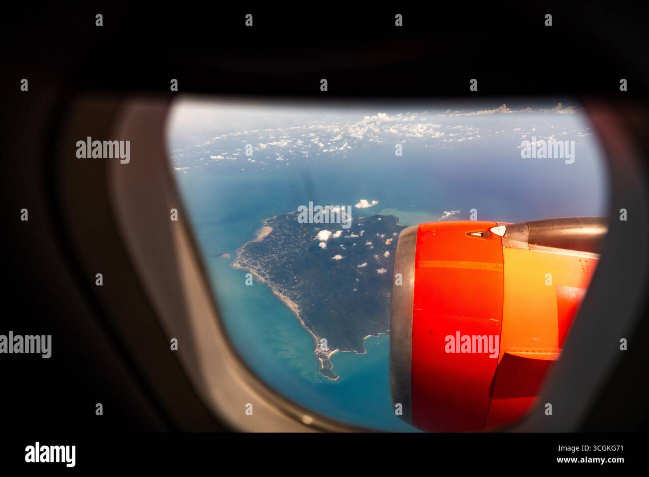 Vue aérienne depuis la fenêtre de l'avion montrant les îles tropicales, la mer turquoise et les nuages avec le moteur de l'avion. Paysage pittoresque symbolisant le voyage, vacati Banque D'Images Vue aérienne depuis la fenêtre de l'avion montrant les îles tropicales, la mer turquoise et les nuages avec le moteur de l'avion. Paysage pittoresque symbolisant le voyage, vacati Banque D'Images