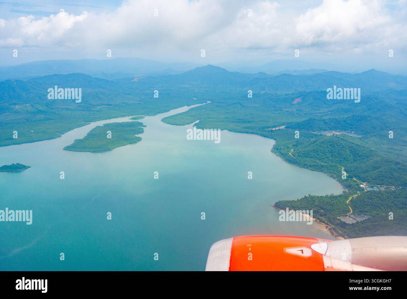 Vue aérienne depuis la fenêtre de l'avion montrant les îles tropicales, la mer turquoise et les nuages avec le moteur de l'avion. Paysage pittoresque symbolisant le voyage, vacati Banque D'Images Vue aérienne depuis la fenêtre de l'avion montrant les îles tropicales, la mer turquoise et les nuages avec le moteur de l'avion. Paysage pittoresque symbolisant le voyage, vacati Banque D'Images