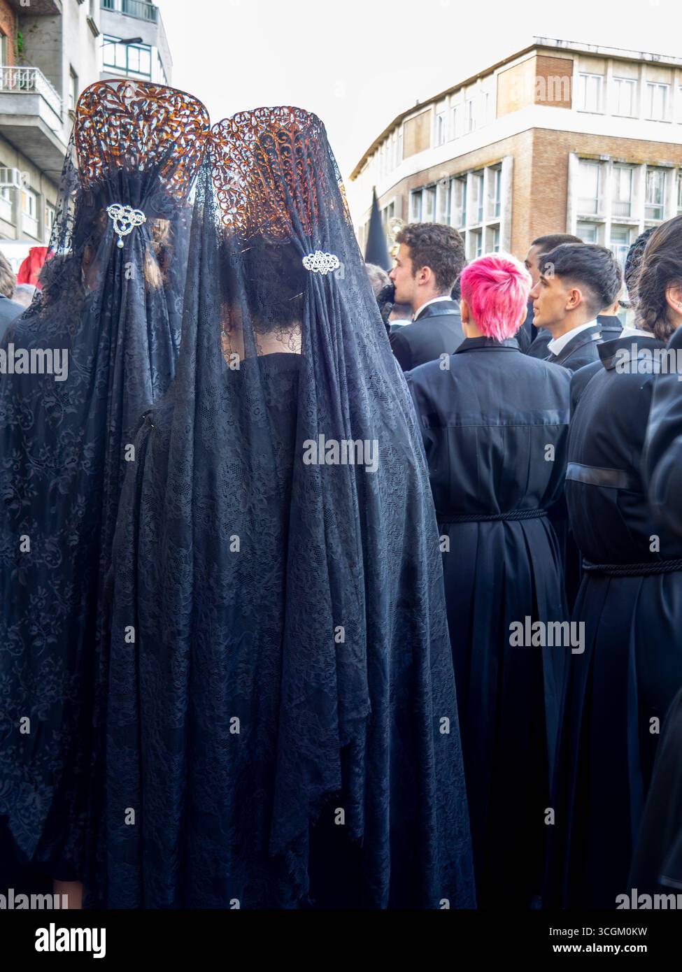 Leon, Espagne. 14 avril 2025. Jeune garçon aux cheveux rougeâtres, attendant dans la rue pour participer aux défilés de Pâques à Léon, Espagne. Banque D'Images