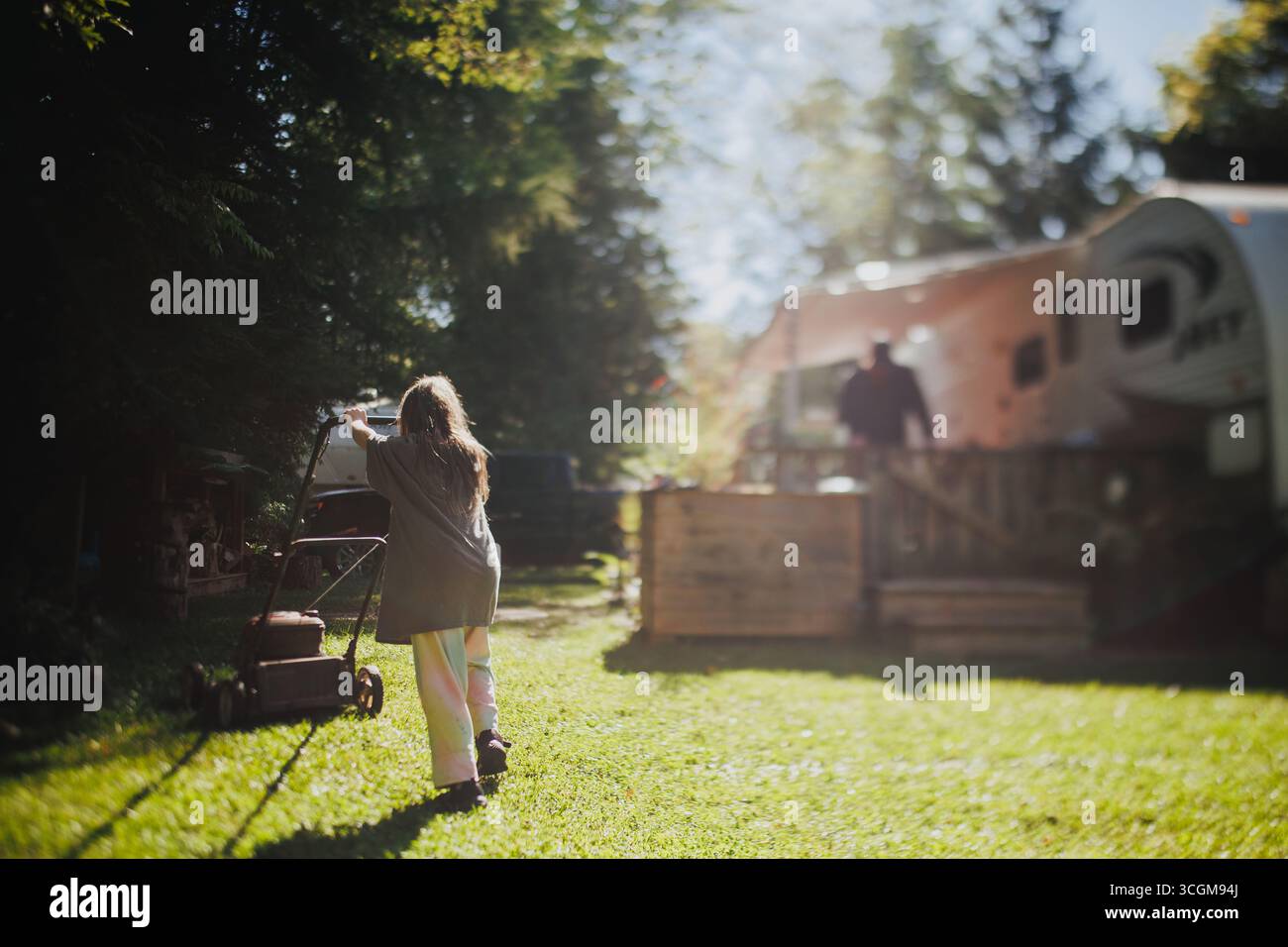 Fille coupant l'herbe dans ses PJ Banque D'Images