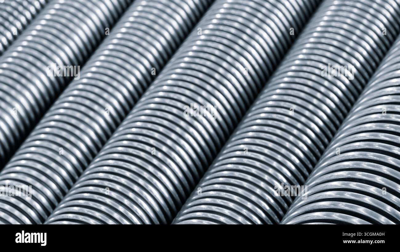 Rangée de tuyaux à haute pression ondulés en acier inoxydable de couleur argentée. les tuyaux sont longs et minces. Fond de concept industriel mécanique ton bleu. Banque D'Images