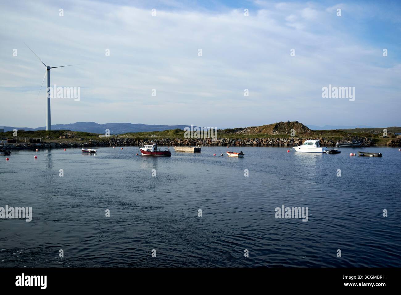 éolienne et petits bateaux de pêche et de loisirs ancrés dans le port du comté de burtonport donegal république d'irlande Banque D'Images