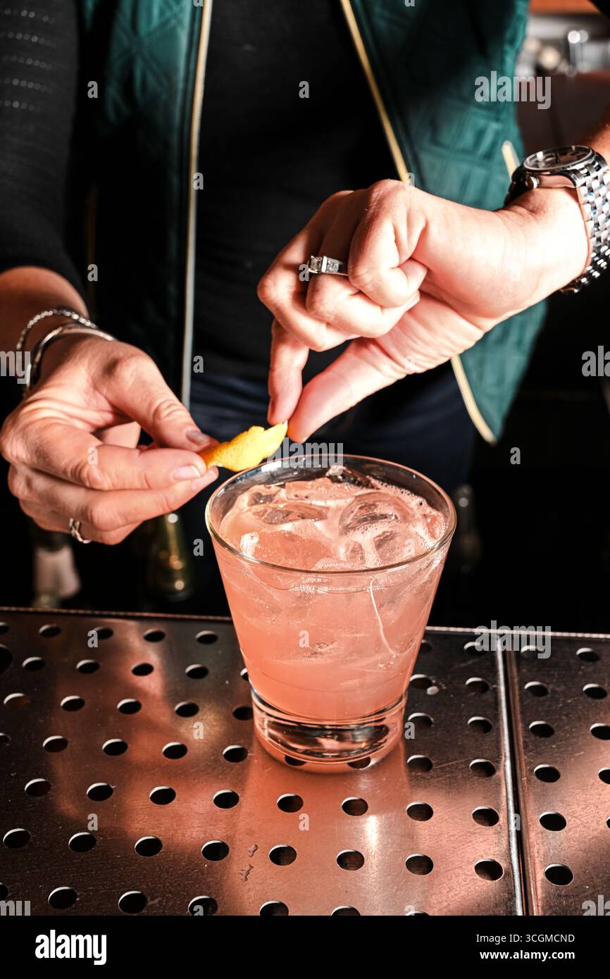 Barman avec coin citron sur le cocktail Banque D'Images