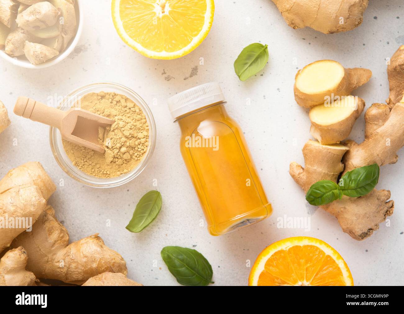 Boisson immunisée au gingembre et à l'orange avec de la racine de gingembre et de la poudre broyée sur fond de cuisine. Banque D'Images