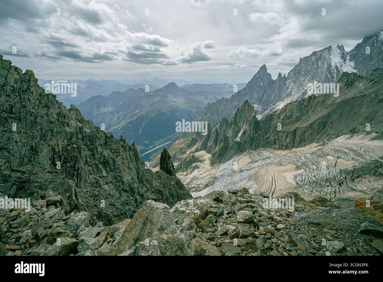 Montagnes de granit avec vue sur les glaciers et les vallées sous les nuages orageux dans les Alpes, mettant en valeur la nature sauvage et les paysages alpins Banque D'Images