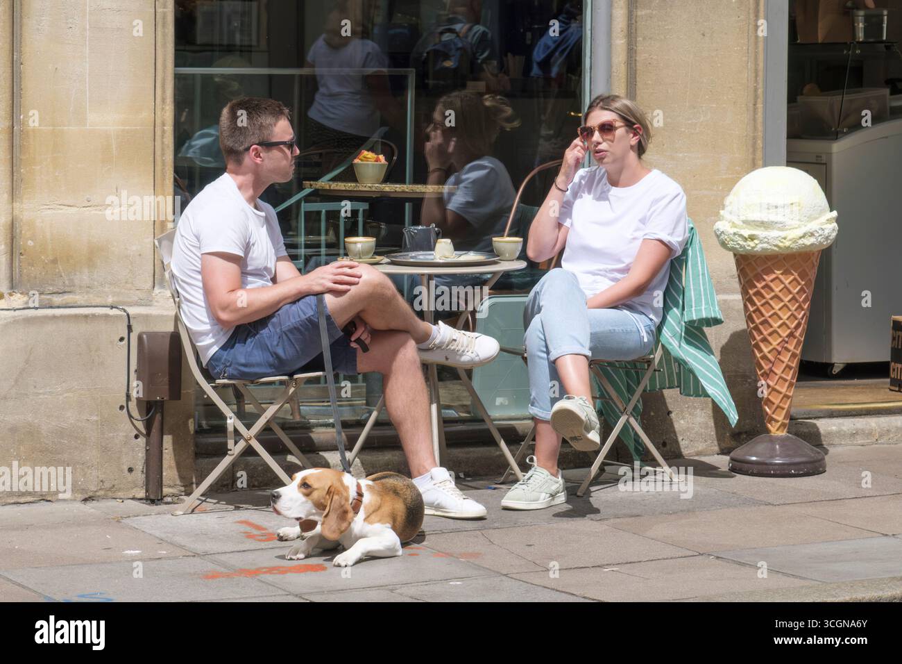Homme et femme chien de compagnie en laine assis à l'extérieur d'un café dans la ville historique de Bath. Café culture sur Quiet Street. Banque D'Images