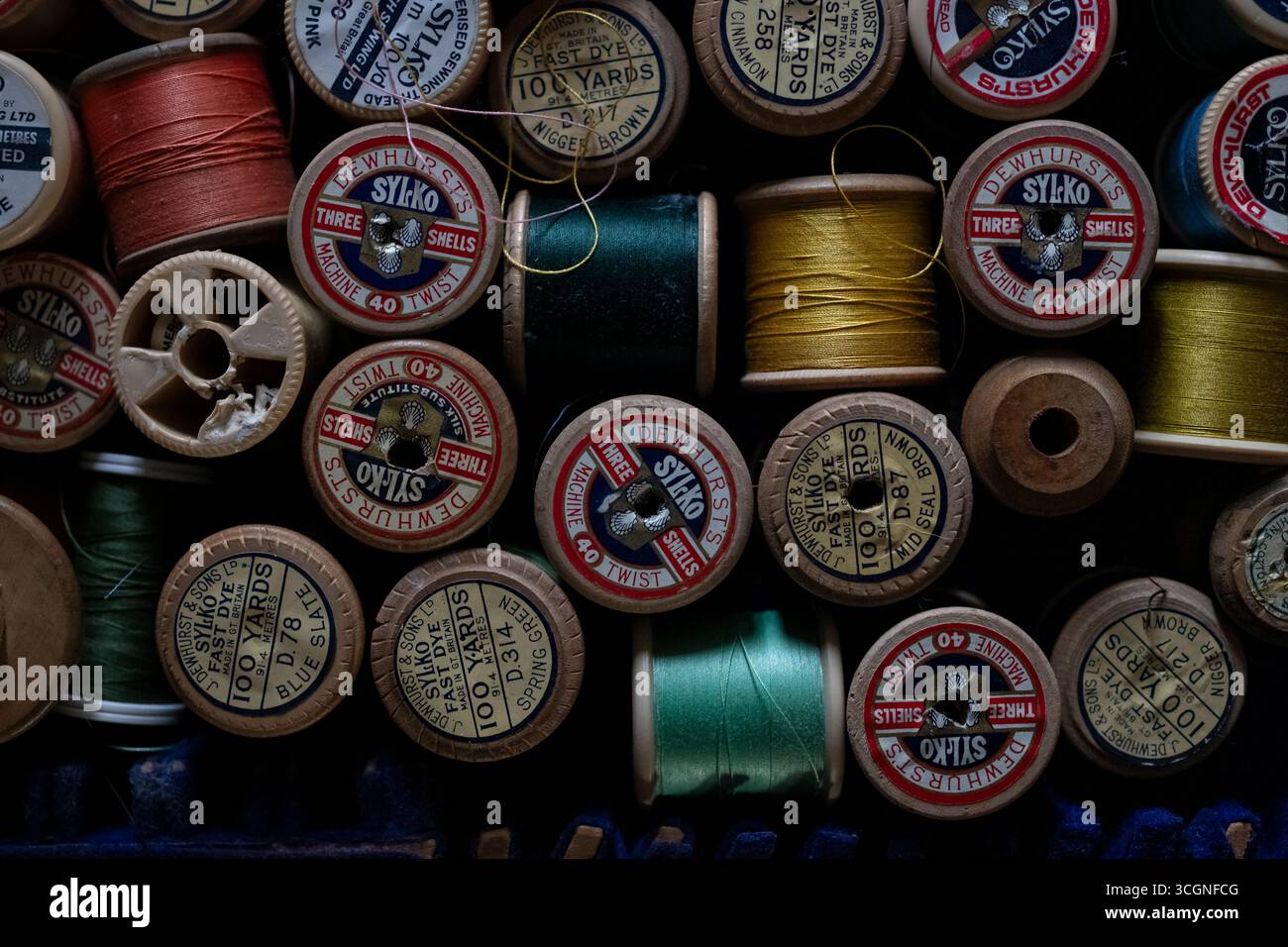 Variété de fils à coudre colorés et bobines de coton dans une boîte à coudre Banque D'Images