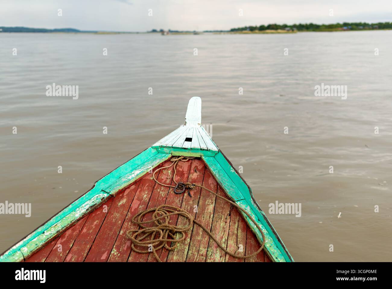 Bateau fluvial en bois de la rivière Ayeyarwaddy Bow Mandalay Myanmar // MANDALAY, Myanmar — la proue d'un bateau fluvial traditionnel en bois est vue d'un point de vue lors de la navigation sur la rivière Ayeyarwaddy (également connue sous le nom de rivière Irrawaddy) près de Mandalay. Cette voie navigable vitale est le fleuve le plus long et le plus important commercialement du Myanmar, s'étendant sur environ 2 170 kilomètres (1 350 miles) du nord au sud. Mandalay, située dans la région de Mandalay, est un centre économique et culturel majeur et a été la dernière capitale royale du Myanmar. La rivière Ayeyarwaddy est cruciale pour le transport, le commerce et le su Banque D'Images