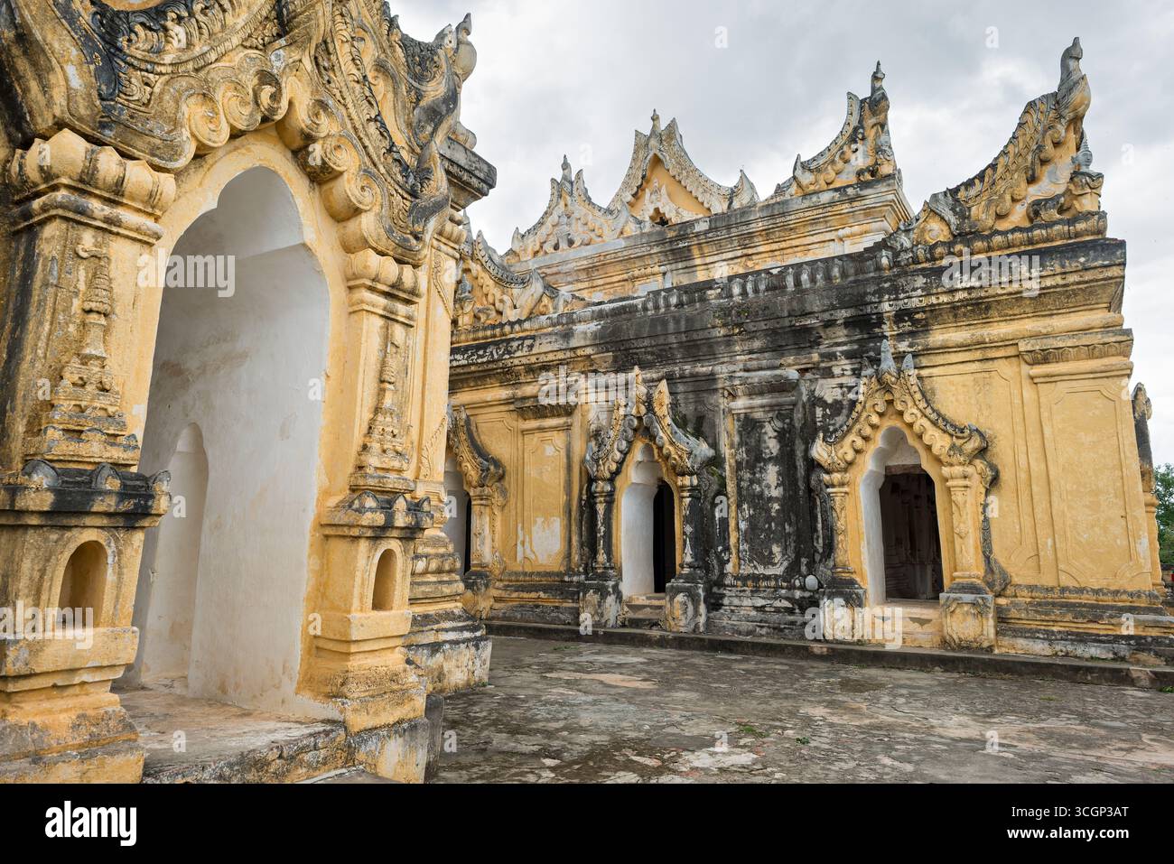 Monastère Maha Aungmye Bonzan architecture birmane en brique Amarapura Myanmar // AMARAPURA, Myanmar — le monastère Maha Aungmye Bonzan (également connu sous le nom de me Nu OK Kyaung ou Monastère en brique) présente une architecture birmane traditionnelle avec des ornements en stuc complexes. Ce monastère bouddhiste historique a été construit en 1822 par Nanmadaw me Nu, la reine en chef du roi Bagyidaw, pour l'abbé royal Nyaunggan Sayadaw. Contrairement à la plupart des monastères birmans traditionnels, qui étaient généralement construits en bois, Maha Aungmye Bonzan est remarquable pour sa construction en maçonnerie. Sa structure en briques en fait un distinctiv Banque D'Images