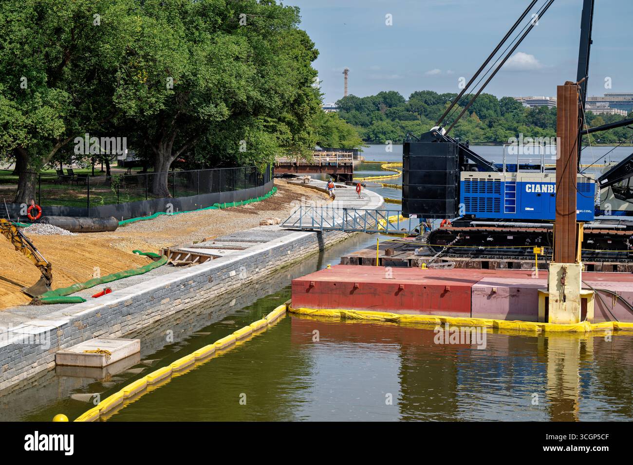 Projet de reconstruction de la digue de Tidal Basin Nouveau mur et équipement Washington DC // WASHINGTON DC — le projet de reconstruction de la digue de Tidal Basin est vu avec de nouvelles sections de mur et de l'équipement lourd, y compris une grue Cianbro, le 14 août 2025. Ce grand projet d’infrastructure vise à reconstruire et à élever les digues qui se détériorent autour du bassin de marée. Les digues existantes, vieilles de plus d'un siècle, succombent à des inondations quotidiennes dues à la combinaison de l'élévation du niveau de la mer et de l'affaissement des terres. Géré par le National Park Service, le projet protège des monuments emblématiques tels que le Jefferson Memoria Banque D'Images Projet de reconstruction de la digue de Tidal Basin Nouveau mur et équipement Washington DC // WASHINGTON DC — le projet de reconstruction de la digue de Tidal Basin est vu avec de nouvelles sections de mur et de l'équipement lourd, y compris une grue Cianbro, le 14 août 2025. Ce grand projet d’infrastructure vise à reconstruire et à élever les digues qui se détériorent autour du bassin de marée. Les digues existantes, vieilles de plus d'un siècle, succombent à des inondations quotidiennes dues à la combinaison de l'élévation du niveau de la mer et de l'affaissement des terres. Géré par le National Park Service, le projet protège des monuments emblématiques tels que le Jefferson Memoria Banque D'Images