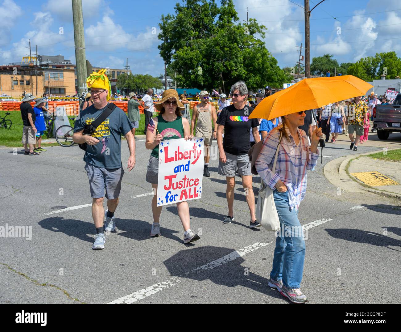 Nouvelle-Orléans, LOUISIANE, États-Unis - 14 juin 2025 : des manifestants anti-Trump avec des pancartes, des drapeaux, un chapeau à tacos et des parapluies participent à la marche du No Kings dans le quartier de Marigny à la Nouvelle-Orléans Banque D'Images