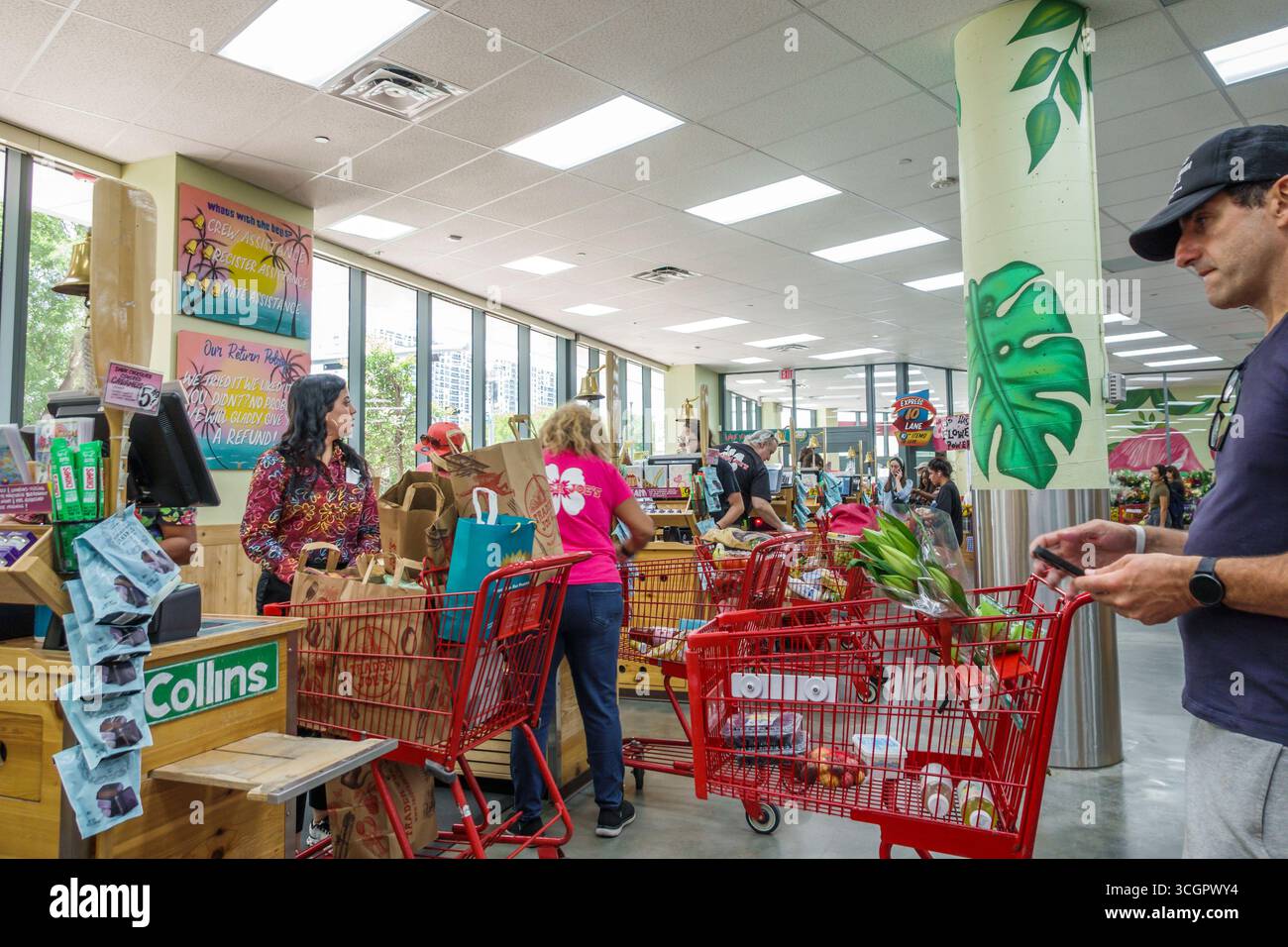 Miami Floride, Trader Joe's, supermarché de magasin d'alimentation d'épicerie, intérieur, caisse comptoir de service de caisse, chariots rouges sacs d'épicerie pleins, a Banque D'Images