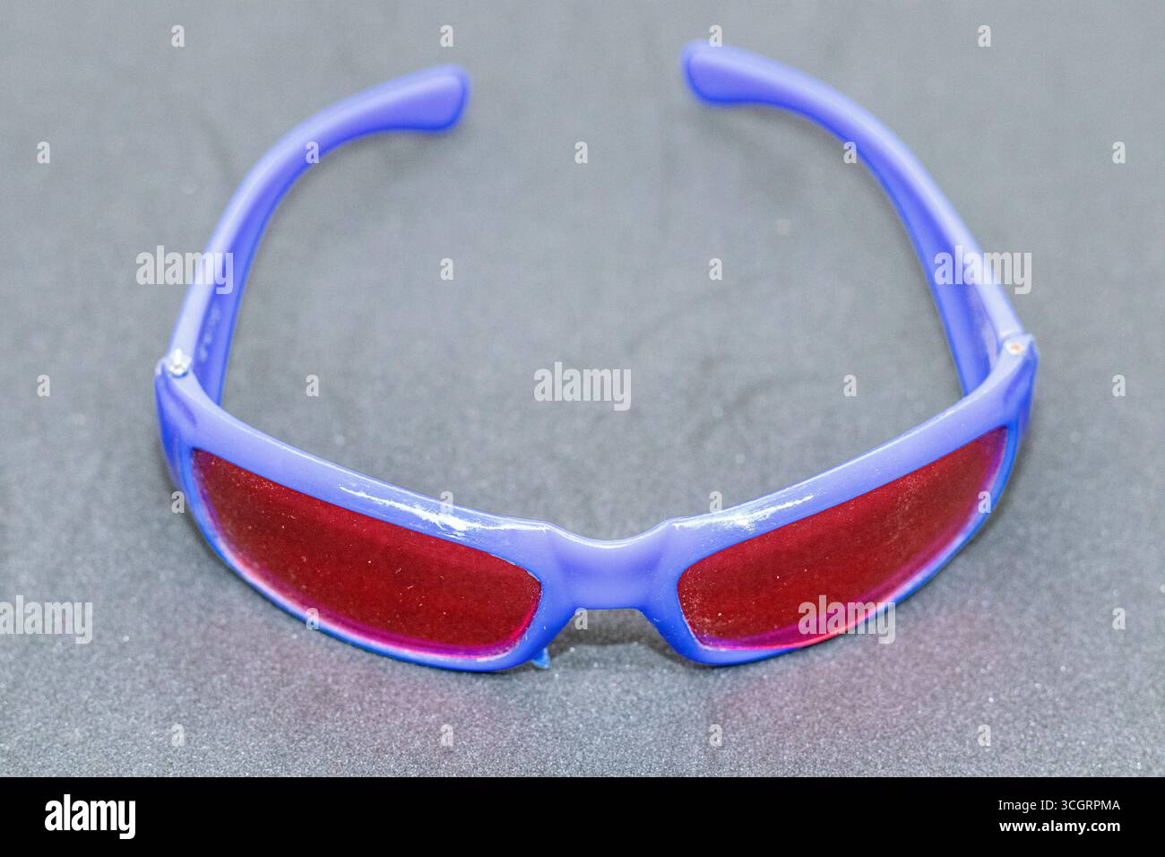 Lunettes de soleil sport tendance avec monture bleue et verres rouges gros plan Banque D'Images