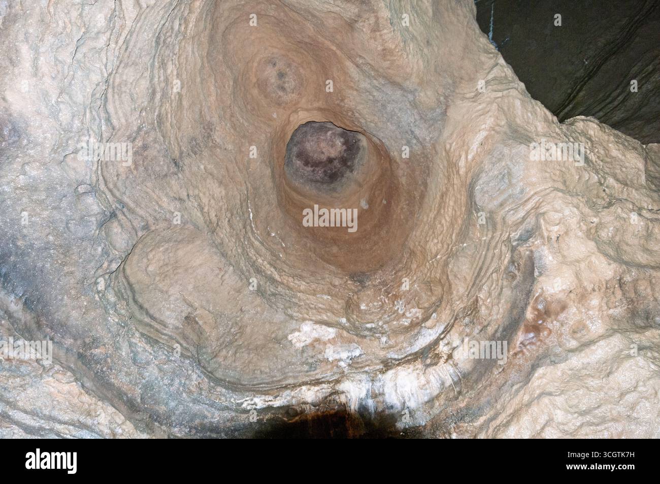 Un gros rocher avec un trou au milieu. Le trou est entouré d'une substance blanche. La roche semble être vieille et altérée Banque D'Images