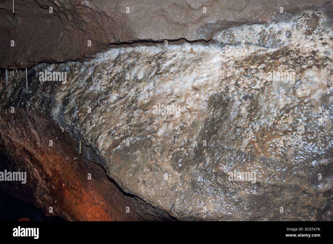 Un rocher avec une substance blanche dessus. La roche est brune et a une texture rugueuse. La substance blanche recouvre la roche et il est un type de minéral. Banque D'Images